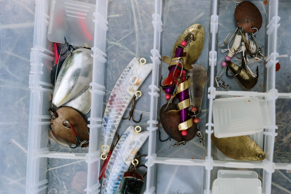 Angelausrüstung Checkliste: geordnet ausgelegte Rute, Rolle, Köderbox und Zange auf einem Holzsteg am See